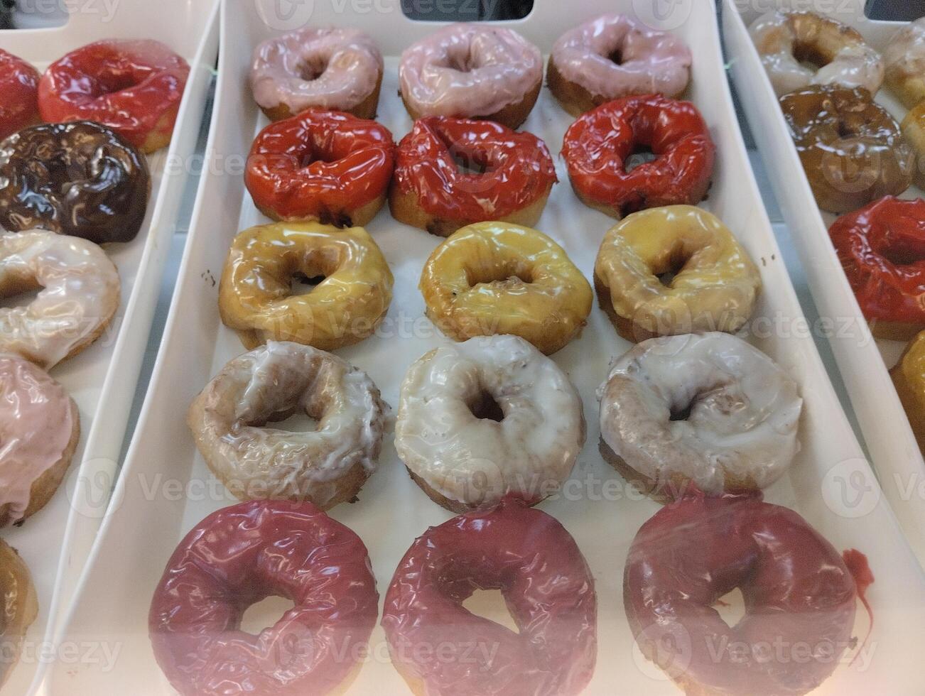 Colored sweet donuts on a tray in a coffee shop bakery. Sweet dishes photo