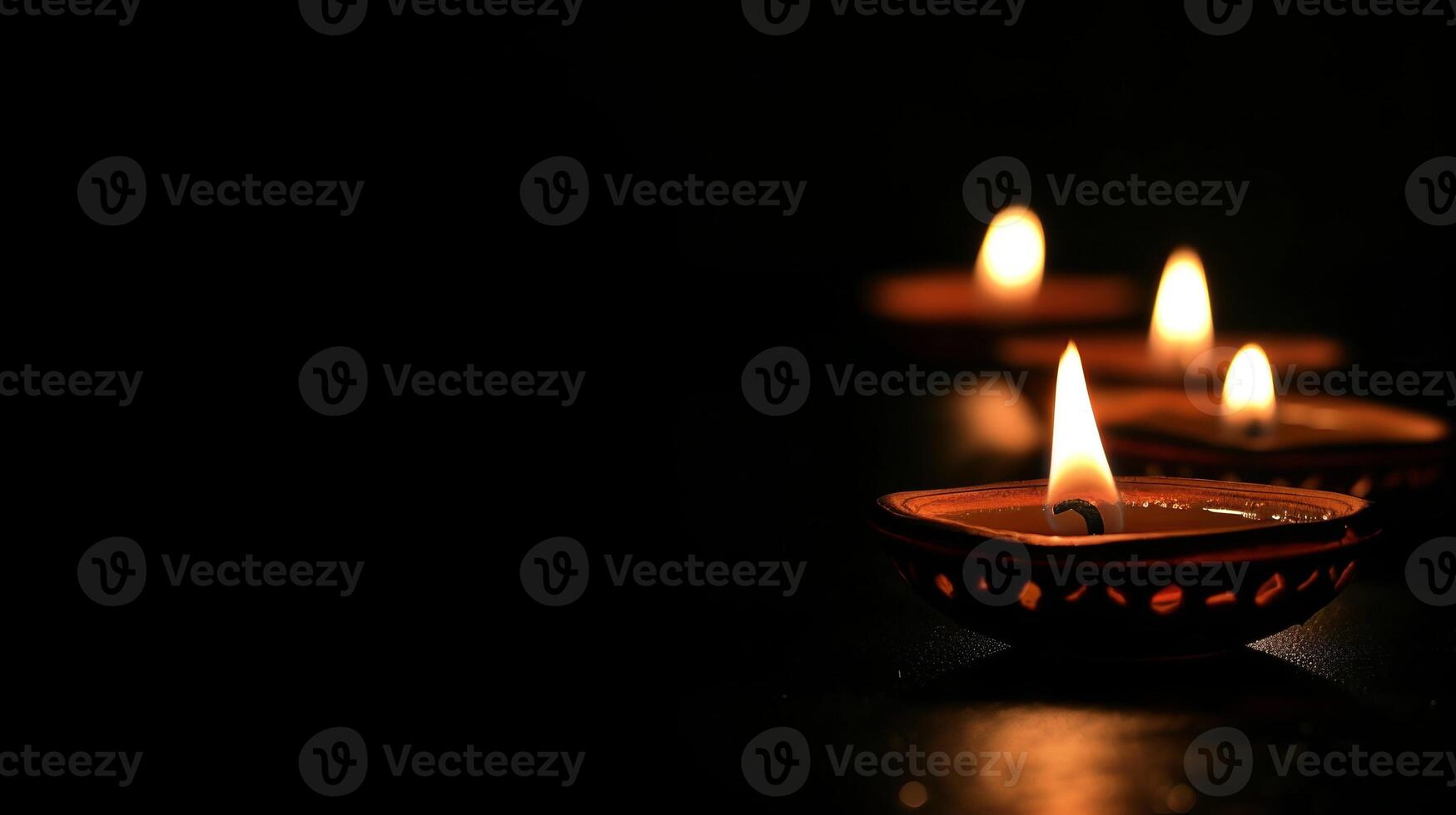 Diya oil lamps against dark background. Warm and inviting Diwali mood. Copy place photo
