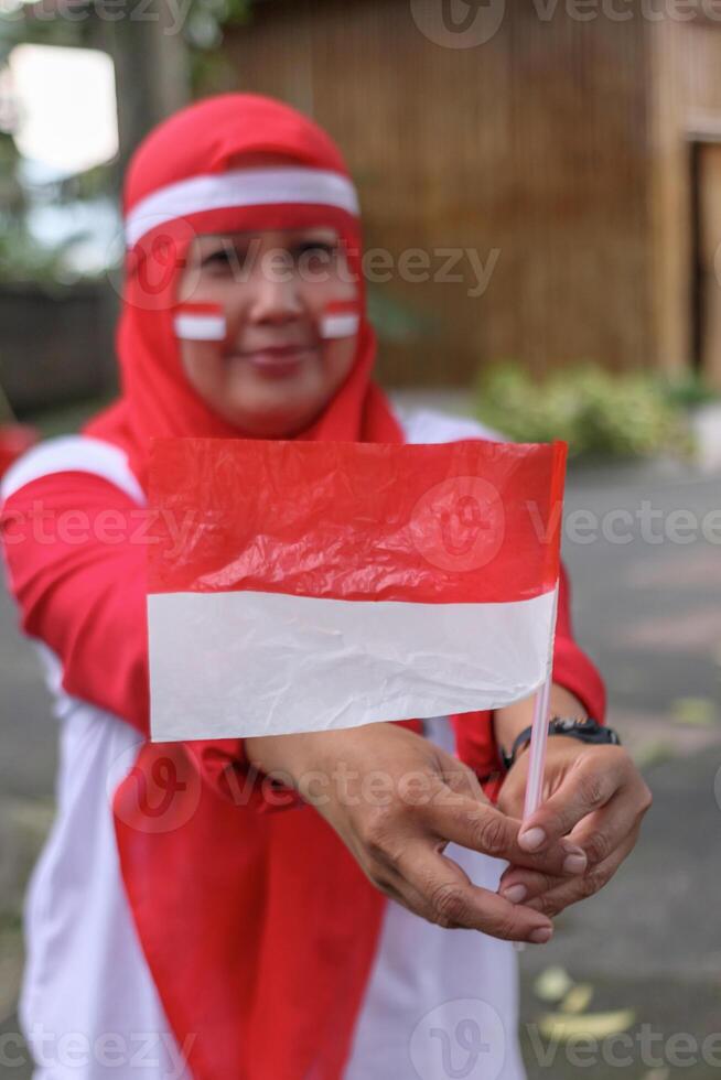 Woman holding Indonesian flag proudly to show national celebration spirit photo