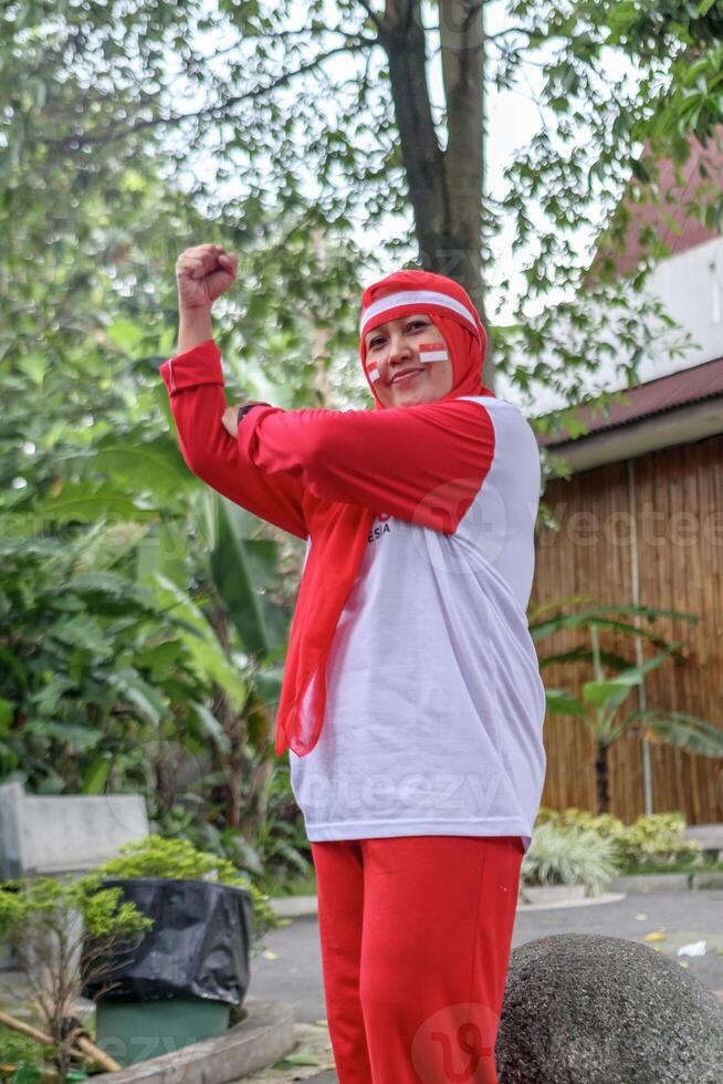 Strong Indonesian woman celebrating independence with proud expression outdoors photo