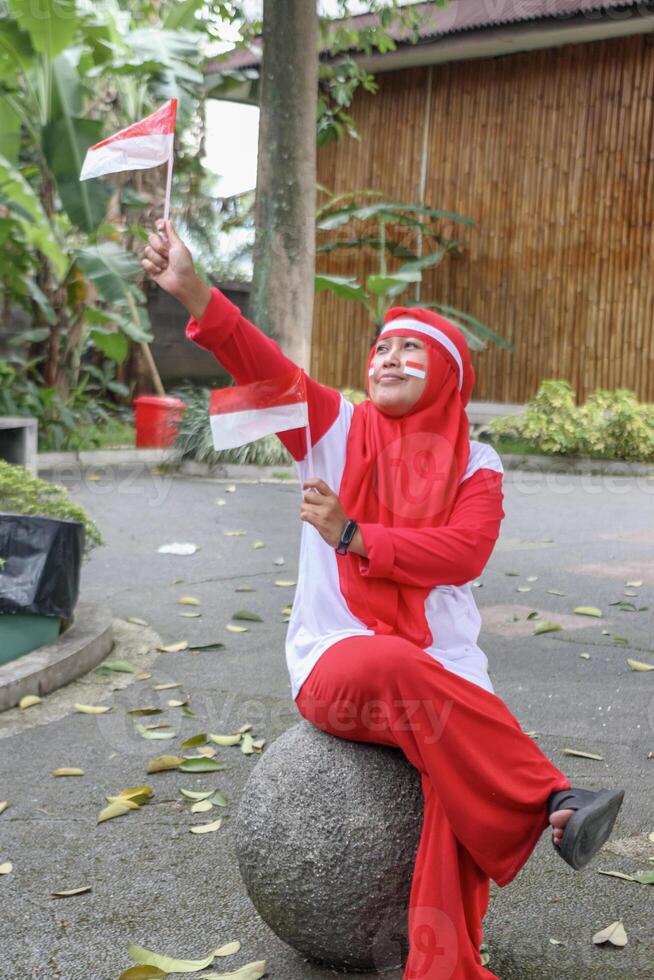 Woman waving flags during patriotic celebration expressing national pride photo