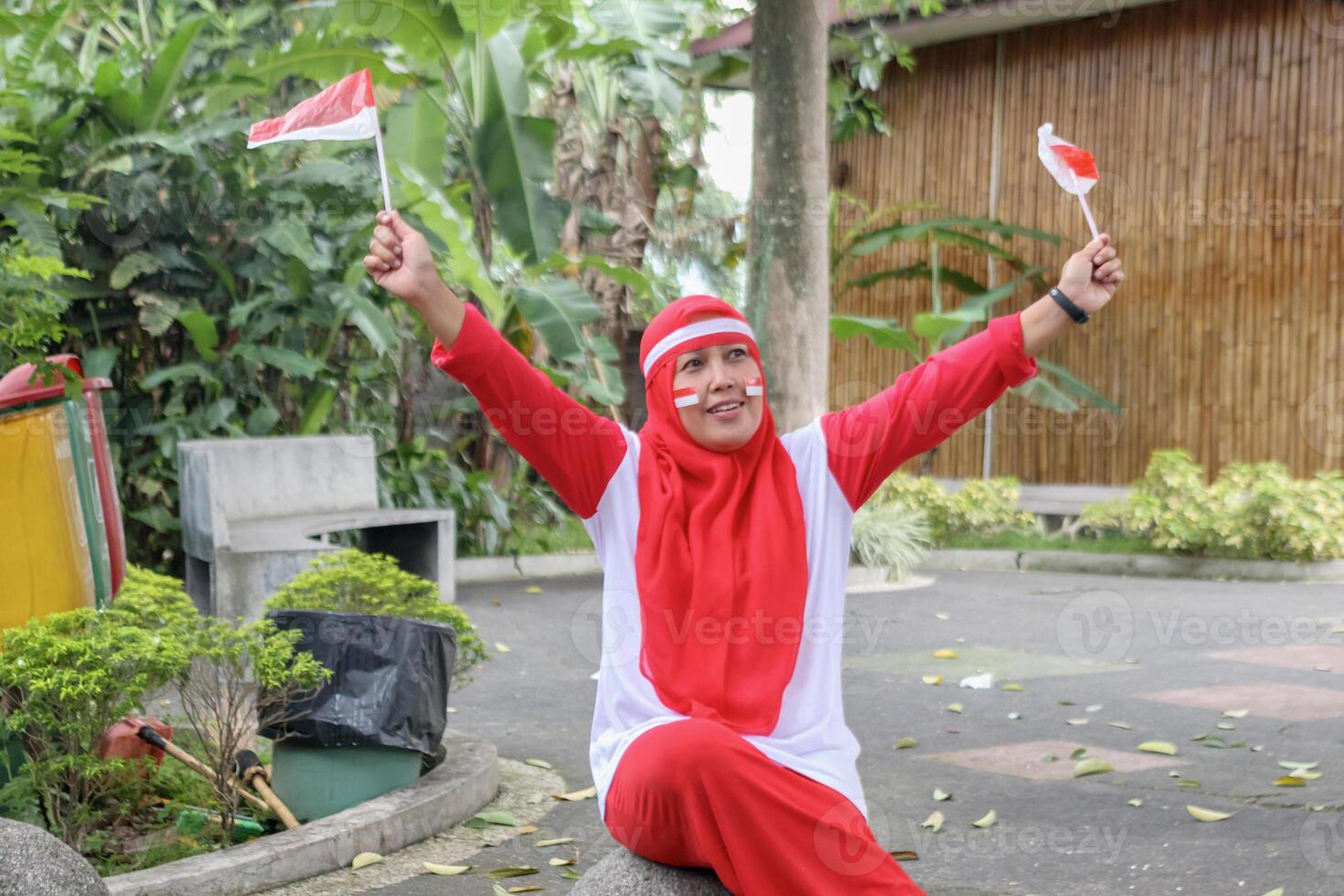 Excited woman holding mini flags celebrating outdoors with happy energy photo