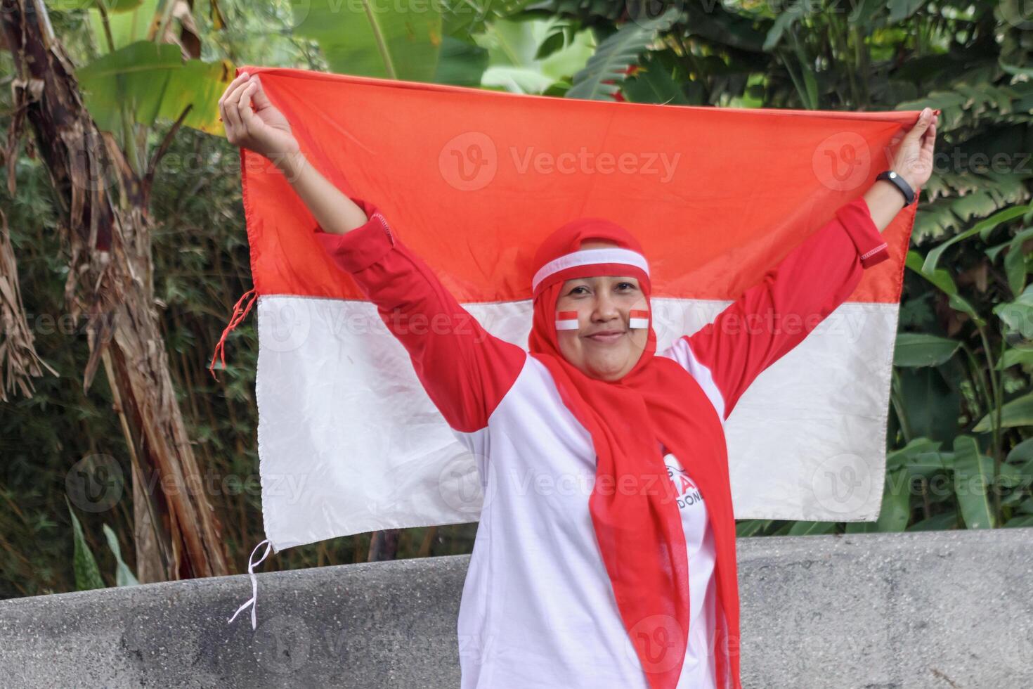 Patriotic woman holding national flag outdoors showing spirit and pride photo
