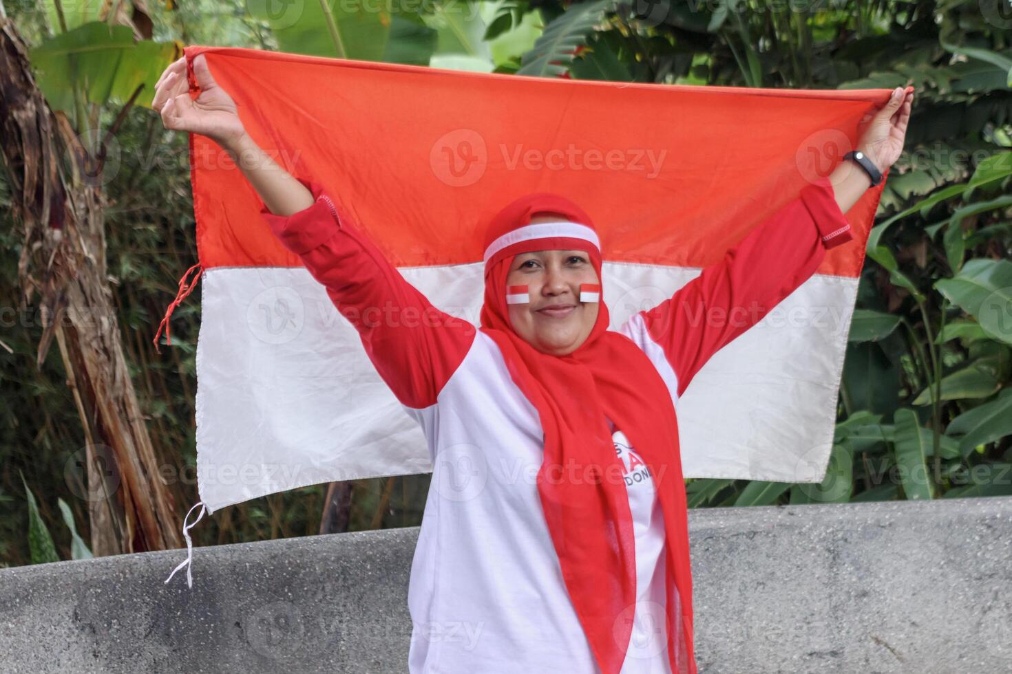 Smiling woman holding flag with national pride in outdoor celebration photo