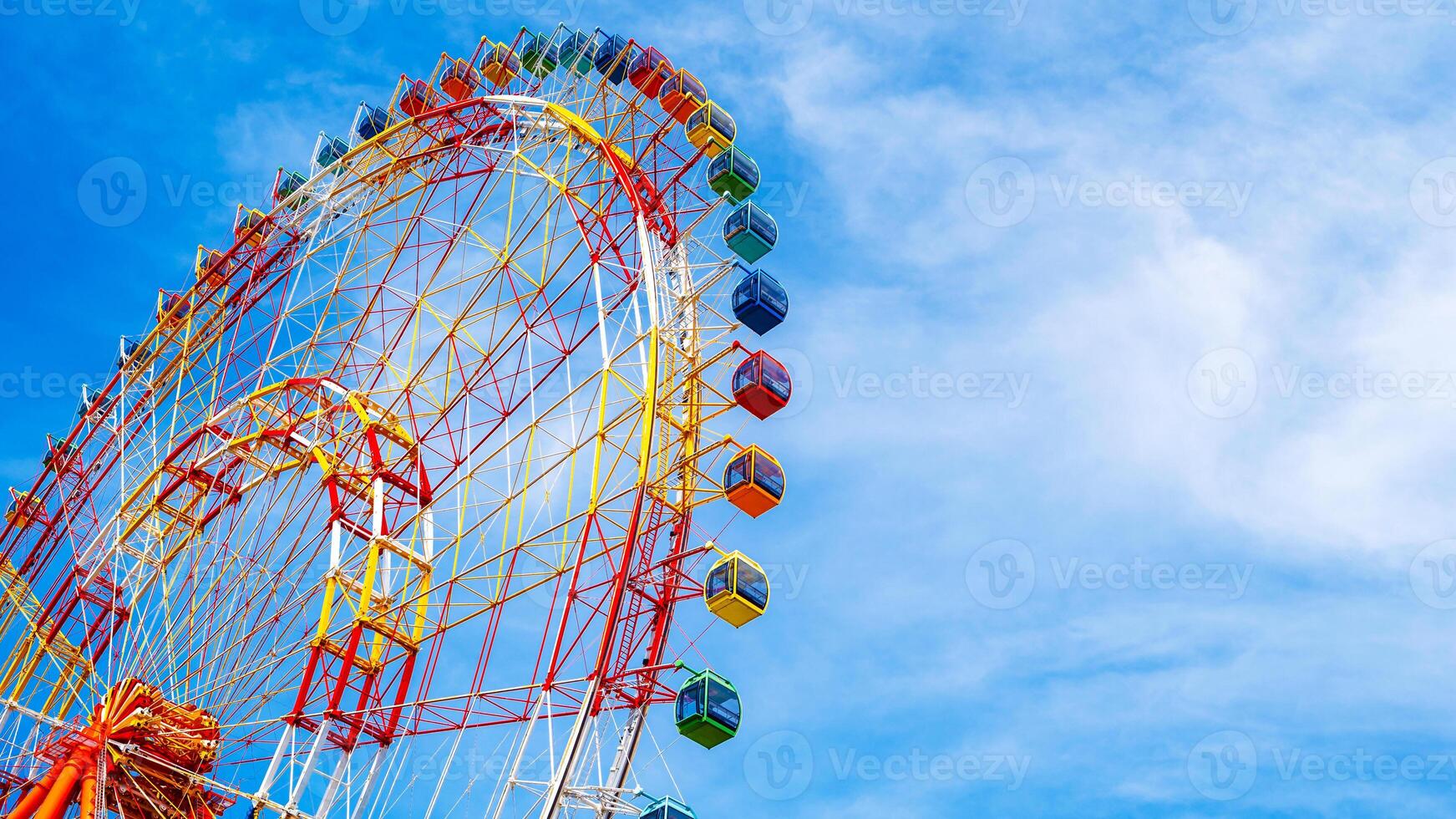 A fragment of a Ferris wheel against the sky in an amusement park. Panoramic view photo