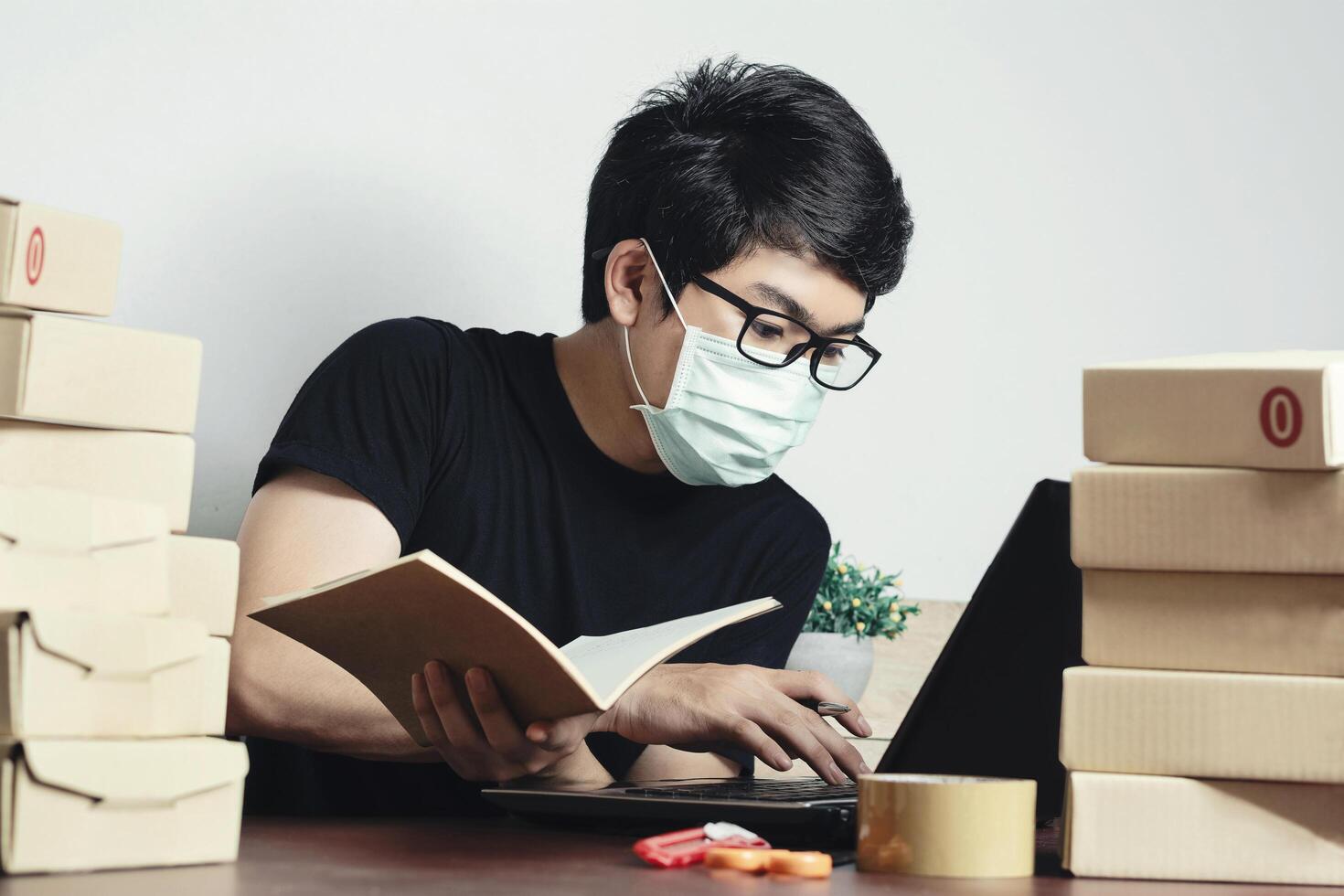 Asian man small business owner Work from home and Wear a mask to protect against Corona virus. Online marketing, Startup SME concept. photo