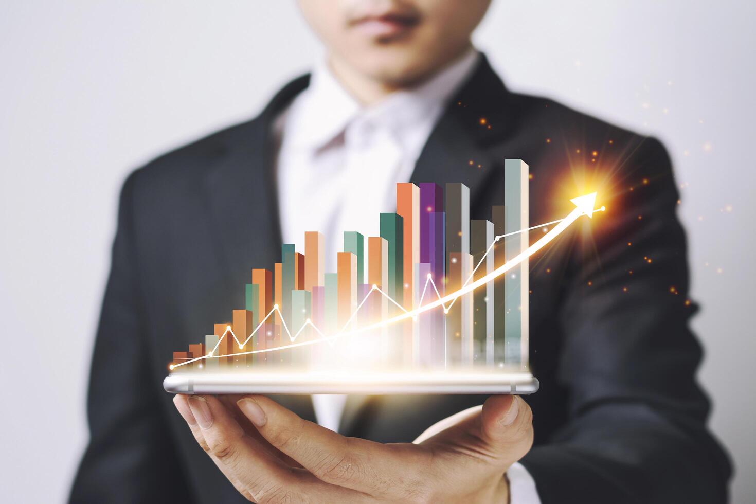 Businessmen Asia holding Smartphone and showing a growing virtual hologram of statistics, graph and chart with arrow up on white background. Stock market. Business growth, planing concept. photo