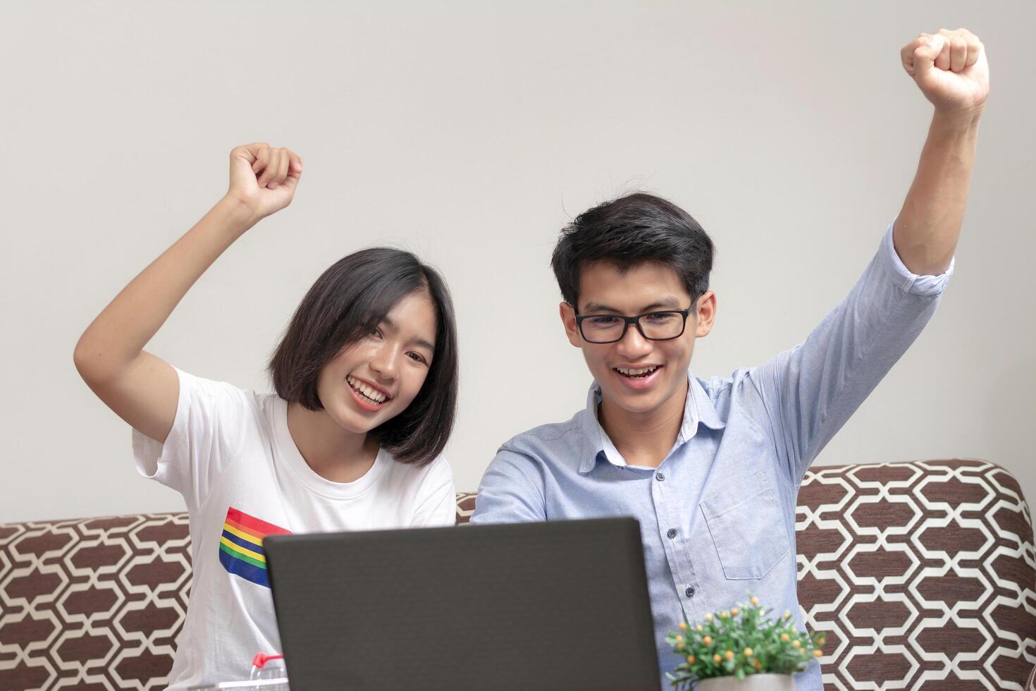 Couples show hands Glad, happy and having fun playing the computer at home, and cheerful, relaxed and successful with his small business. Gen Z business people. photo