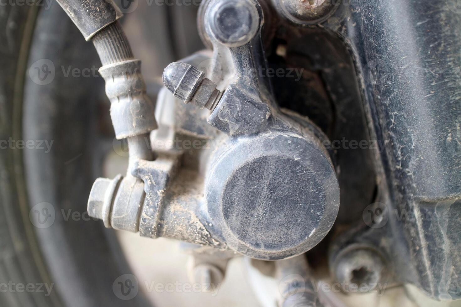 Close up of dusty motorcycle brake caliper part photo