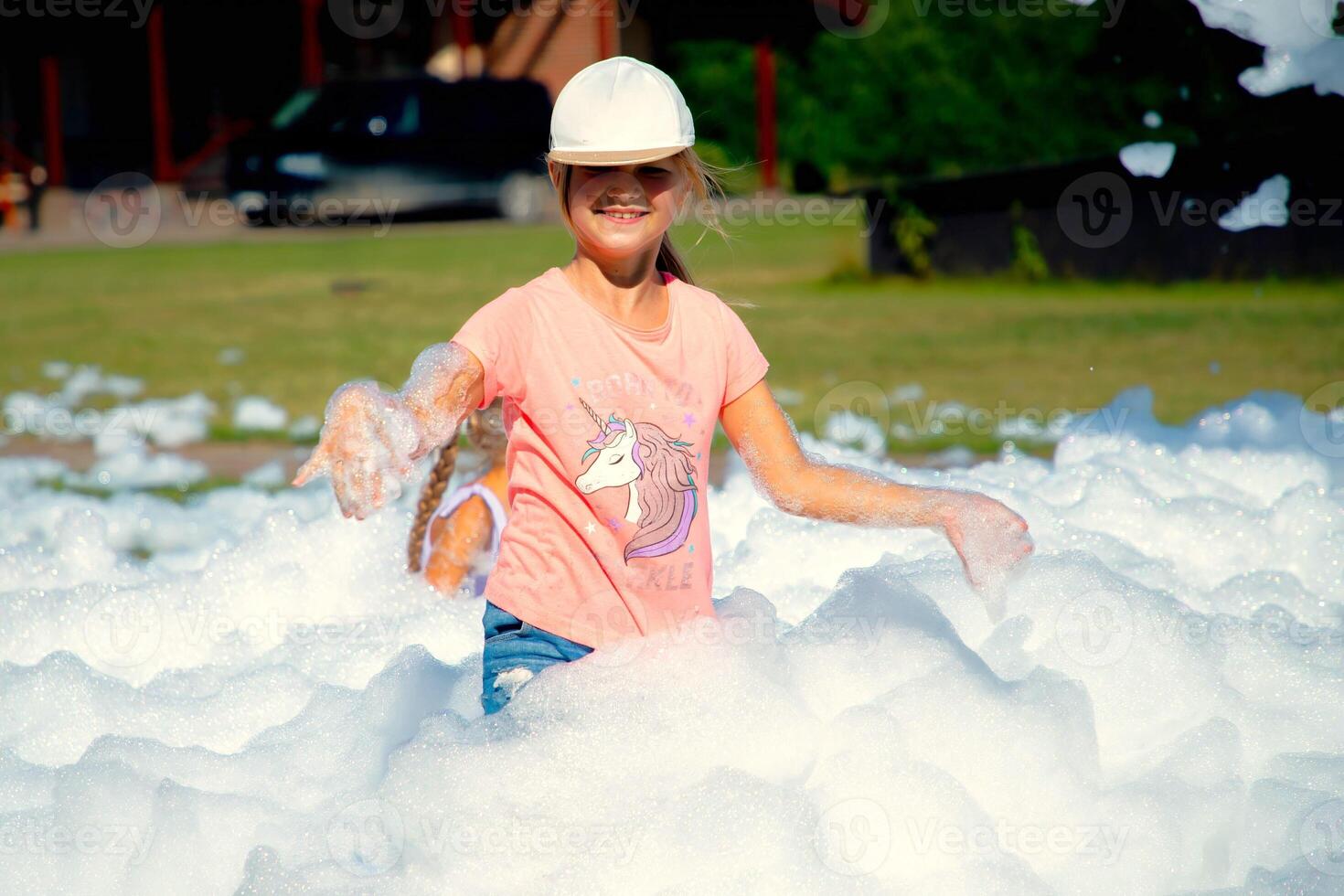 Child girl playing in outdoor foam party. photo