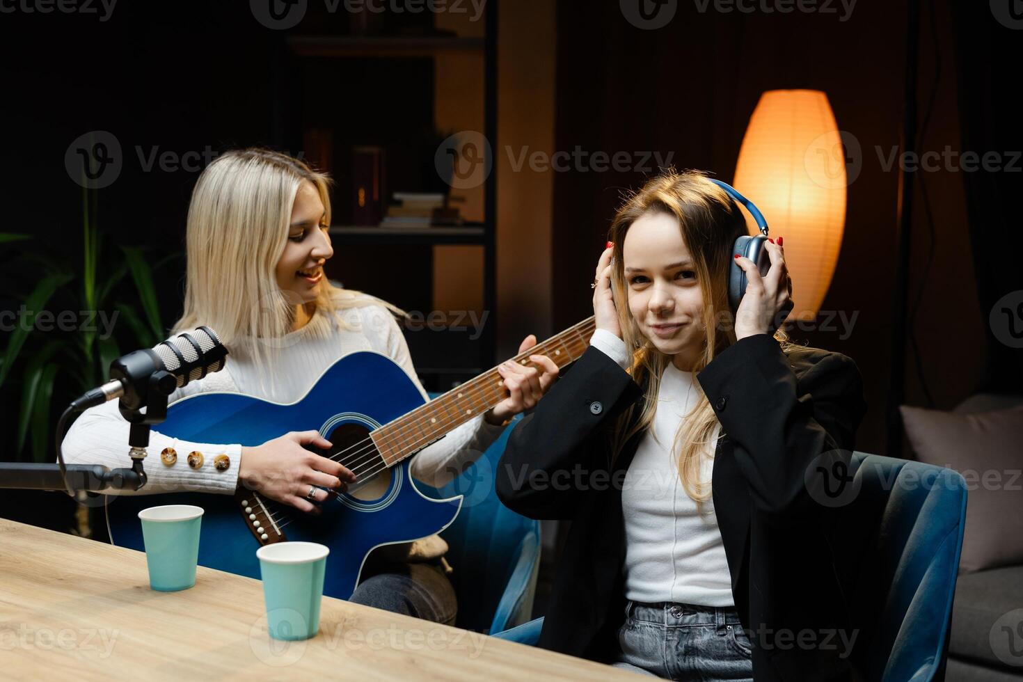 Musicians recording a song with acoustic guitar and microphone in a home studio photo