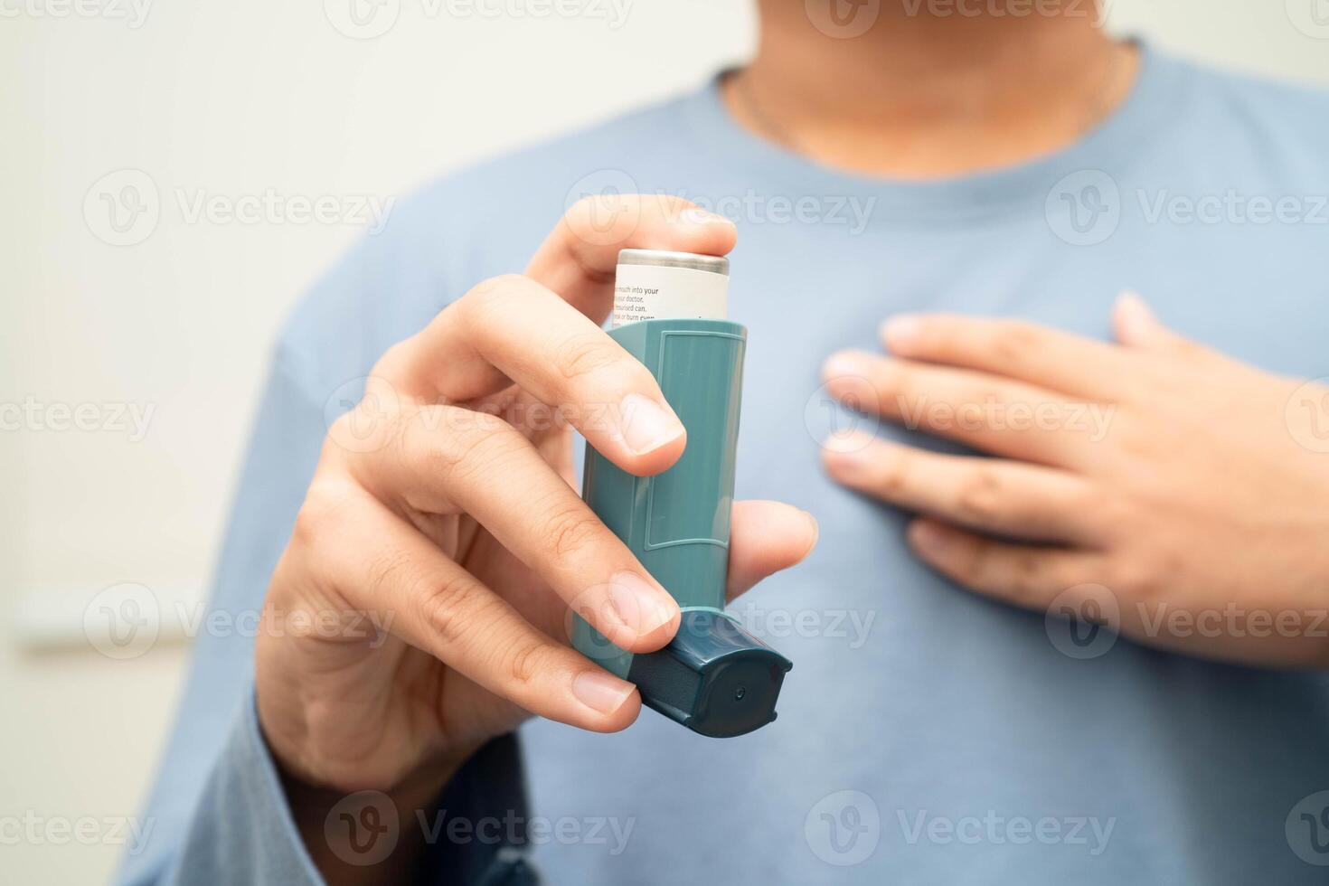 Asthma and chronic obstructive pulmonary disease COPD, Asian young man using metered dose inhaler photo