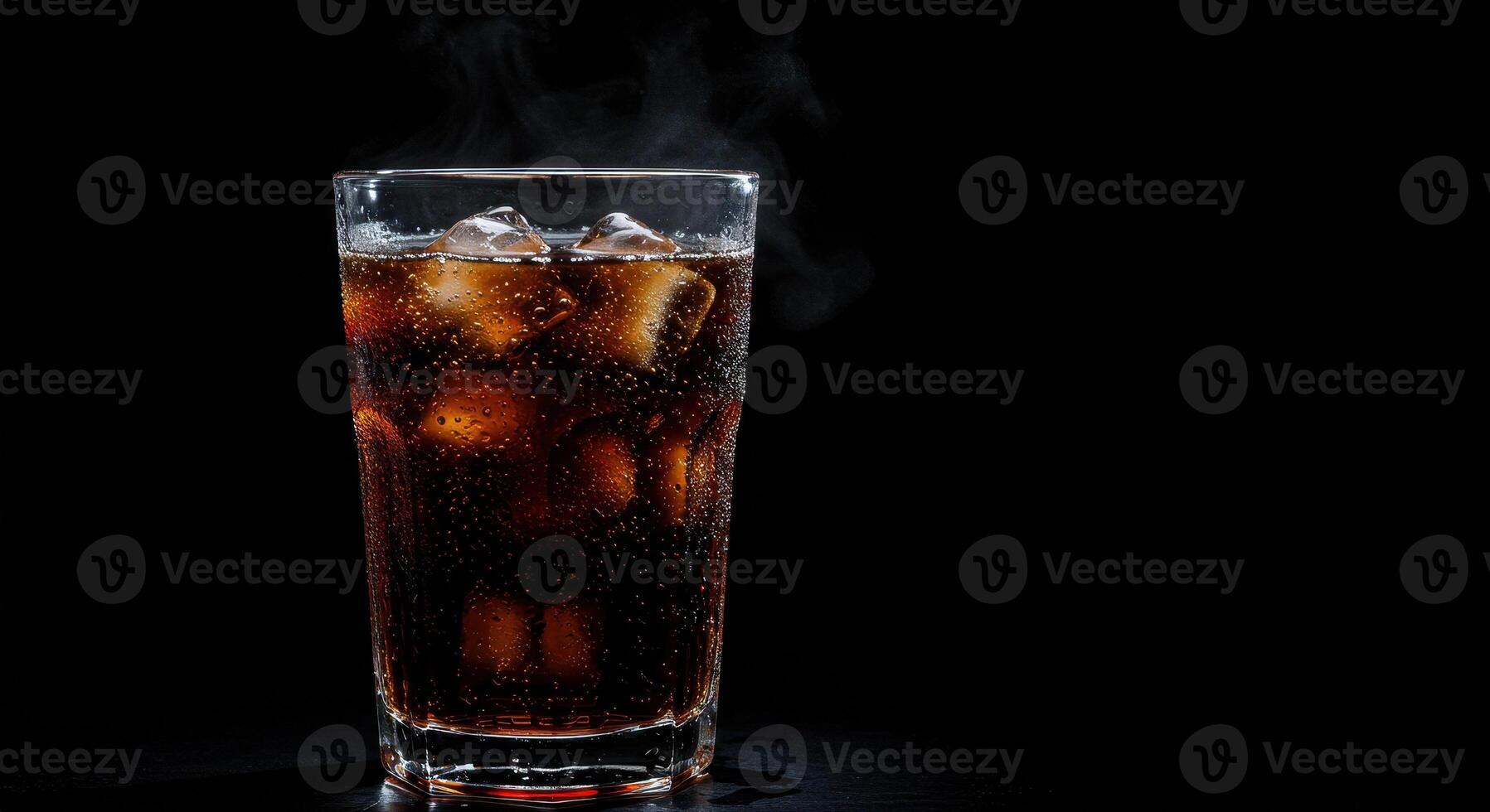 Refreshing dark soda with ice cubes in glass on black background. Fizzy drink with bubbles and condensation. Cold beverage concept for summer refreshment. photo
