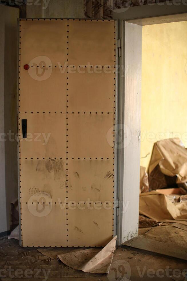 Padded door with visible wear and foot marks grime in an abandoned building photo