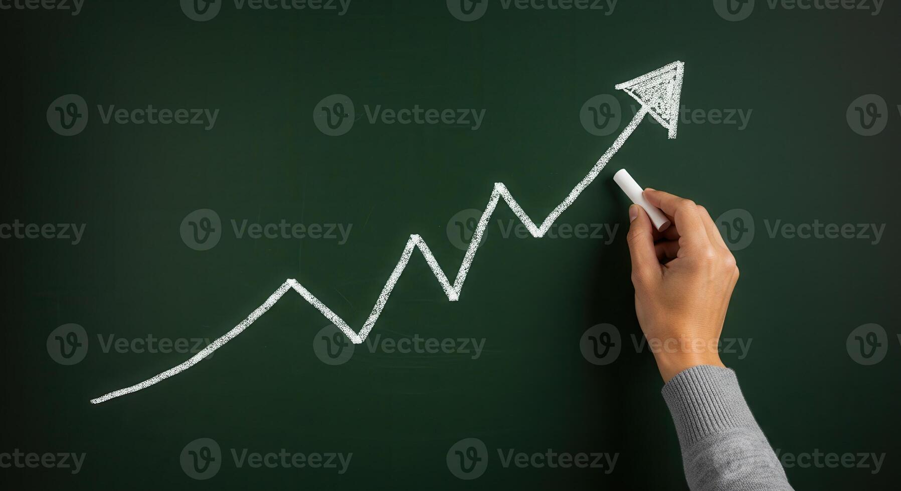 Hand drawing an upward trending line graph with an arrow on a green chalkboard, symbolizing business growth and success. photo