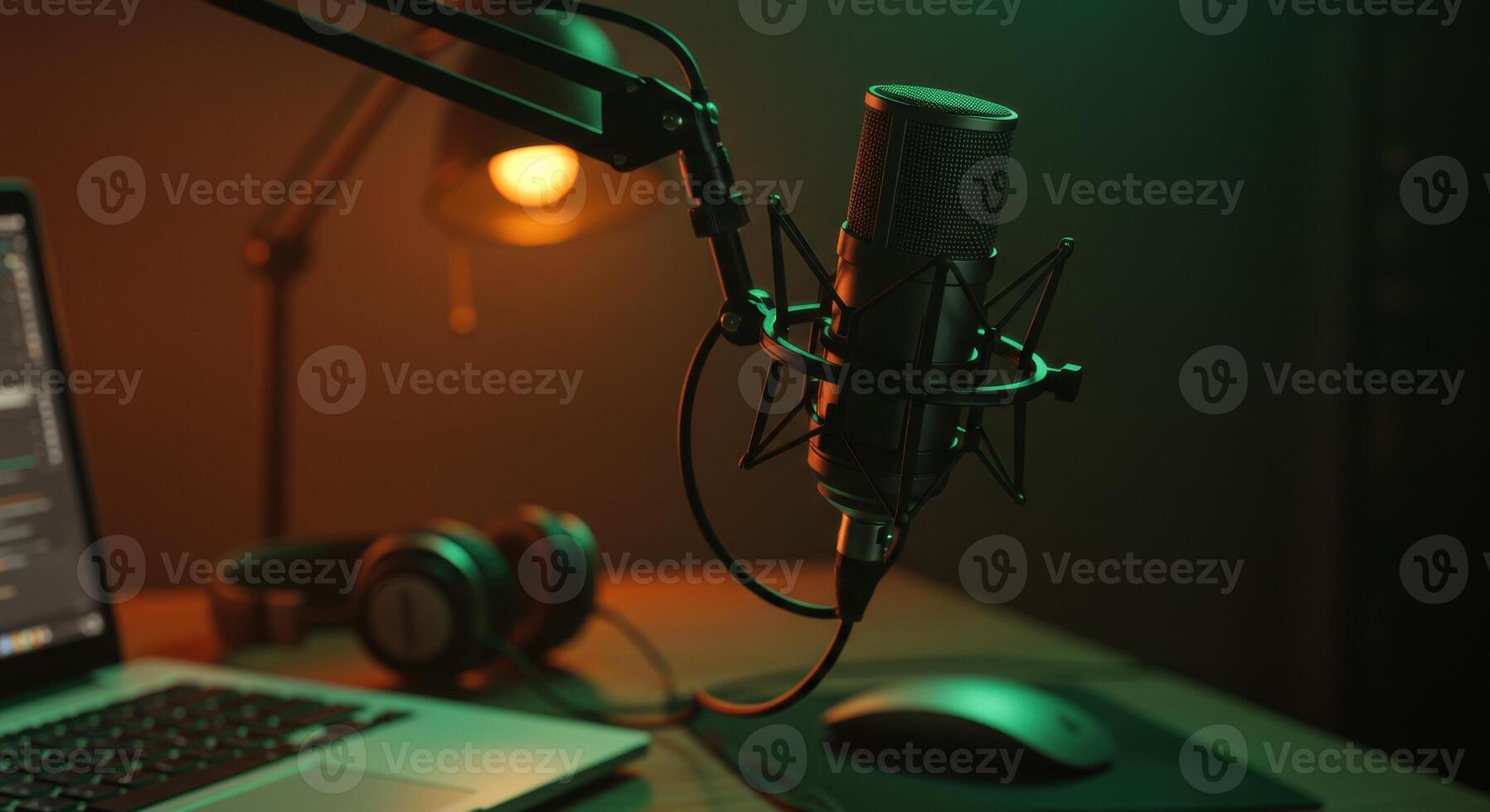 Condenser microphone on boom arm over desk with laptop, headphones, mouse, and lamp. Studio setup for podcasting, streaming, or recording audio. photo