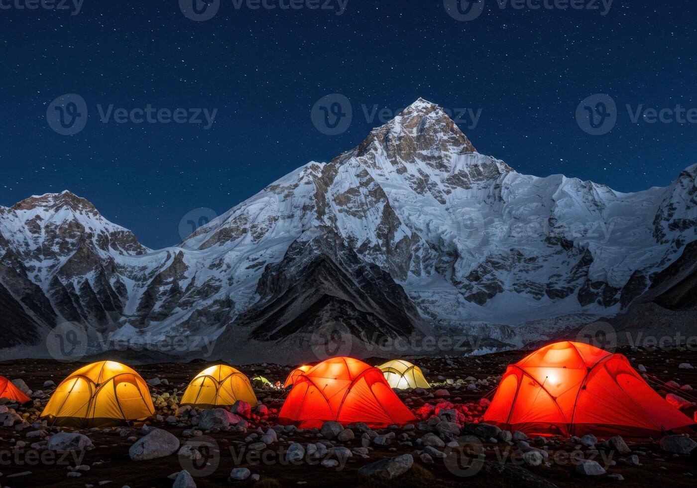 Illuminated tents in a mountain camp under a starry sky. Snowy peaks in the background. Adventure, travel, and outdoor concept with space for text. photo