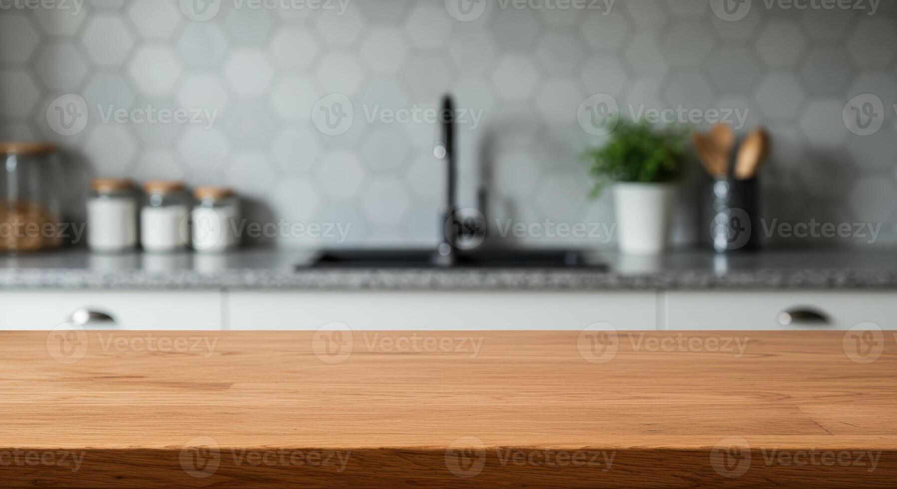 Wooden table in blurred kitchen interior with sink, plant, and utensils. Countertop surface for product display and food preparation concept. photo