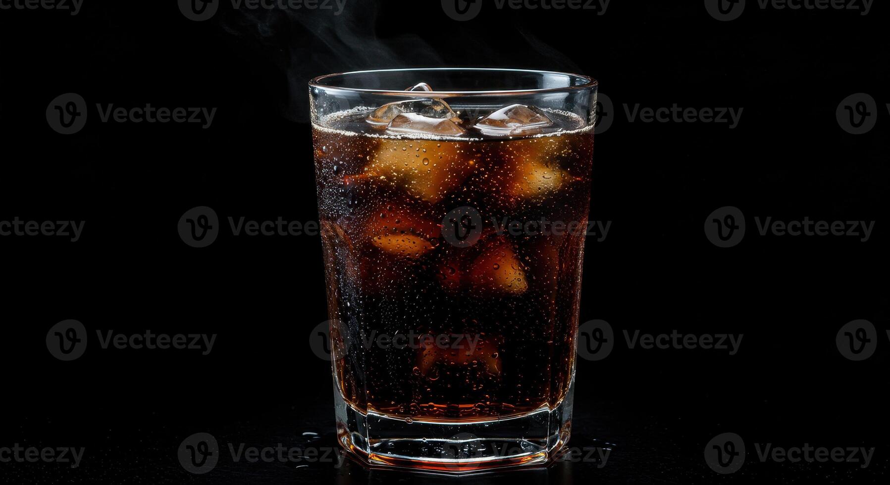 Refreshing root beer with ice cubes in a glass on a dark background. Cold drink with condensation and steam for summer refreshment. photo