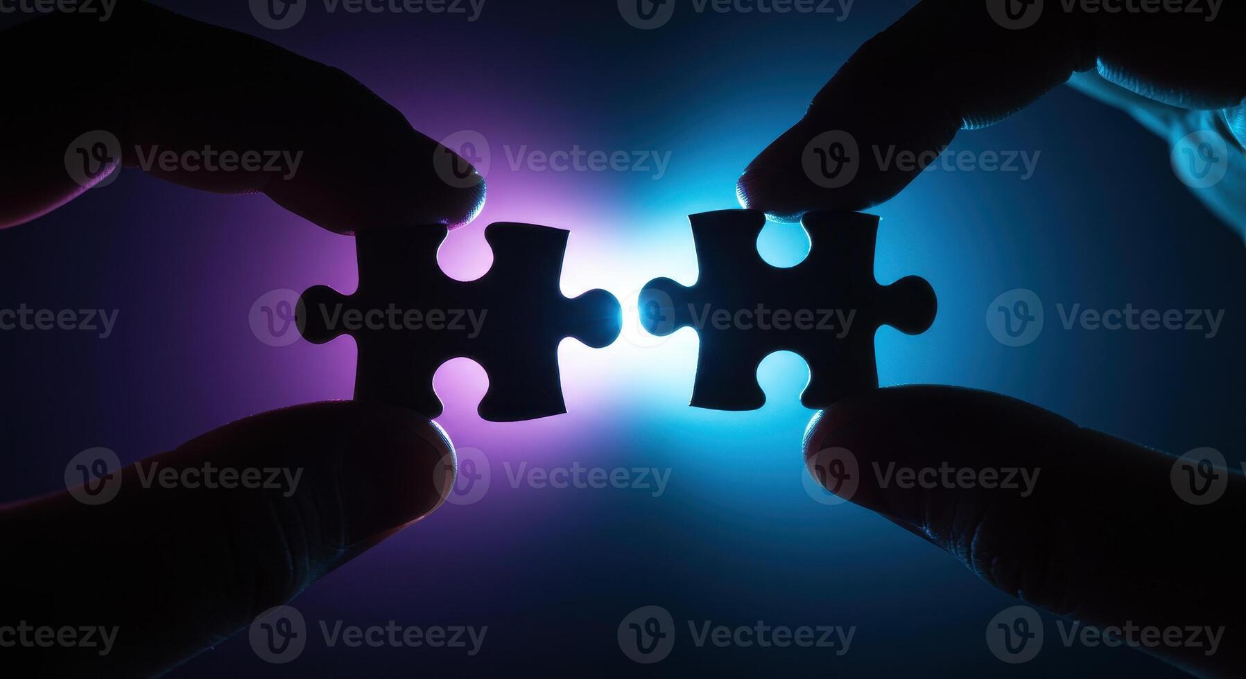 Two hands connecting jigsaw puzzle pieces, symbolizing teamwork, strategy, and problem solving, against a vibrant blue and purple light backdrop. photo