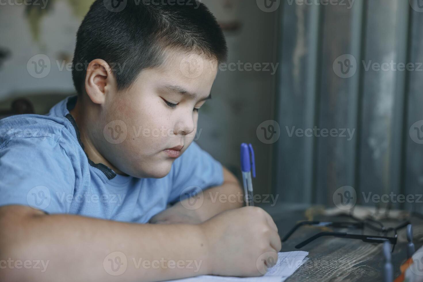 asian boy think deeply, homework near vintage paneling, mouth slightly open in concentration, tutoring, parenting blog, educational service photo