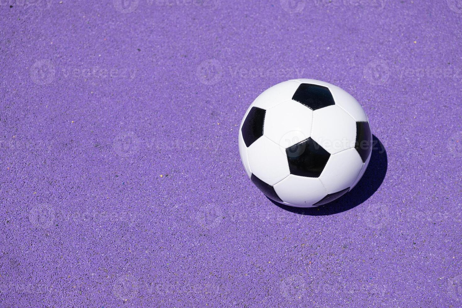 Classic leather soccer ball isolated on purple color field. Copy space photo