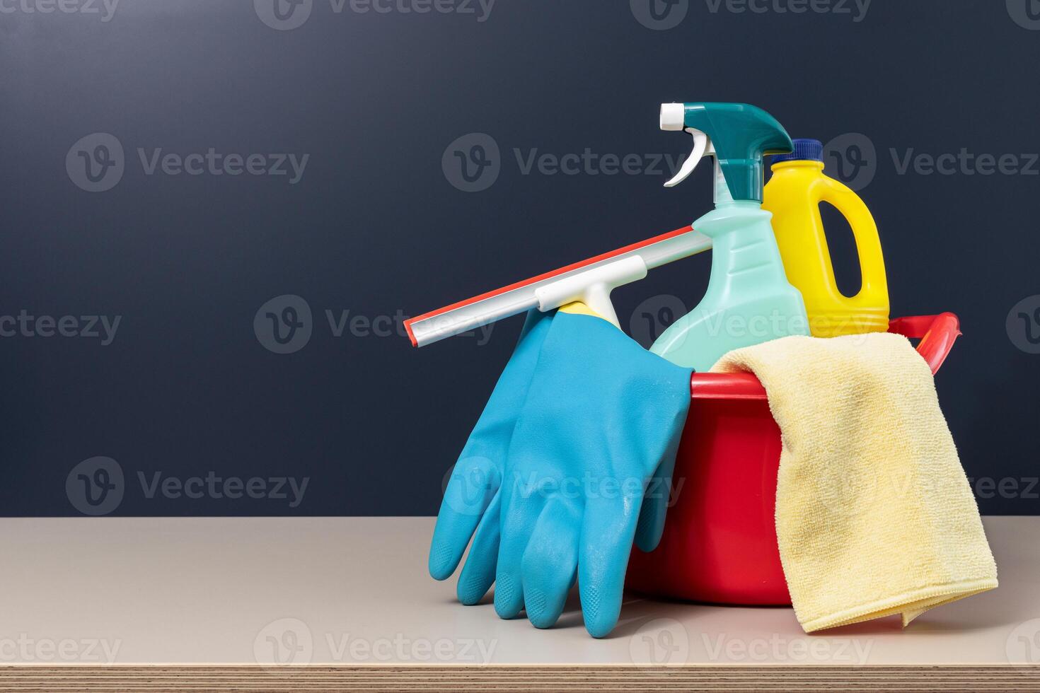 Cleaning supplies in bucket on table with copy space photo