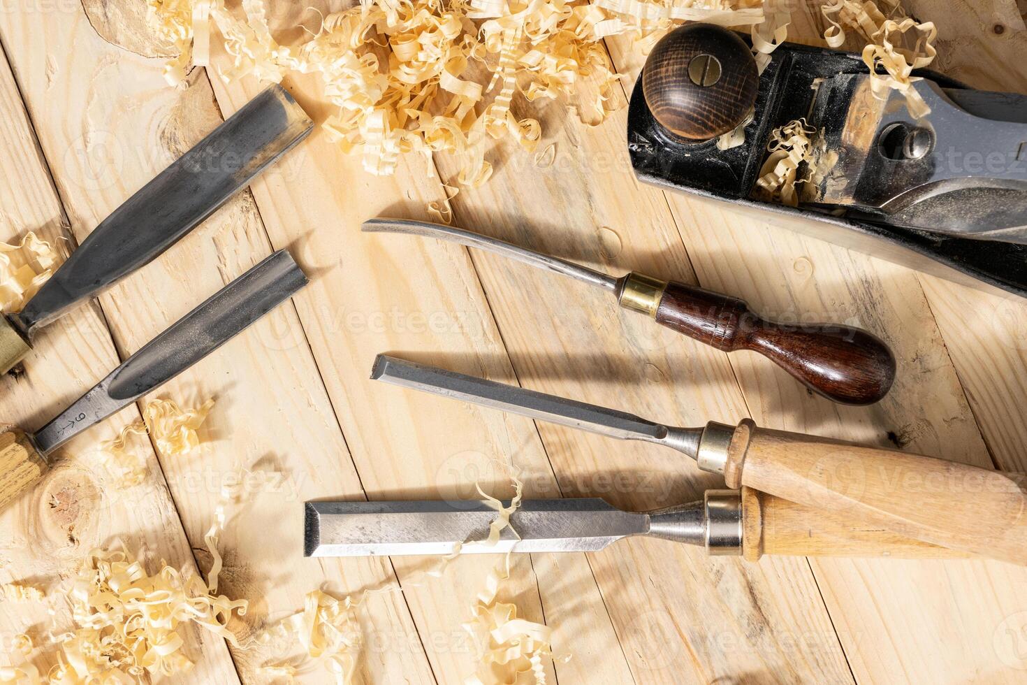 Top view of a traditional carpenter tools and wood shavings lying on wooden planks photo
