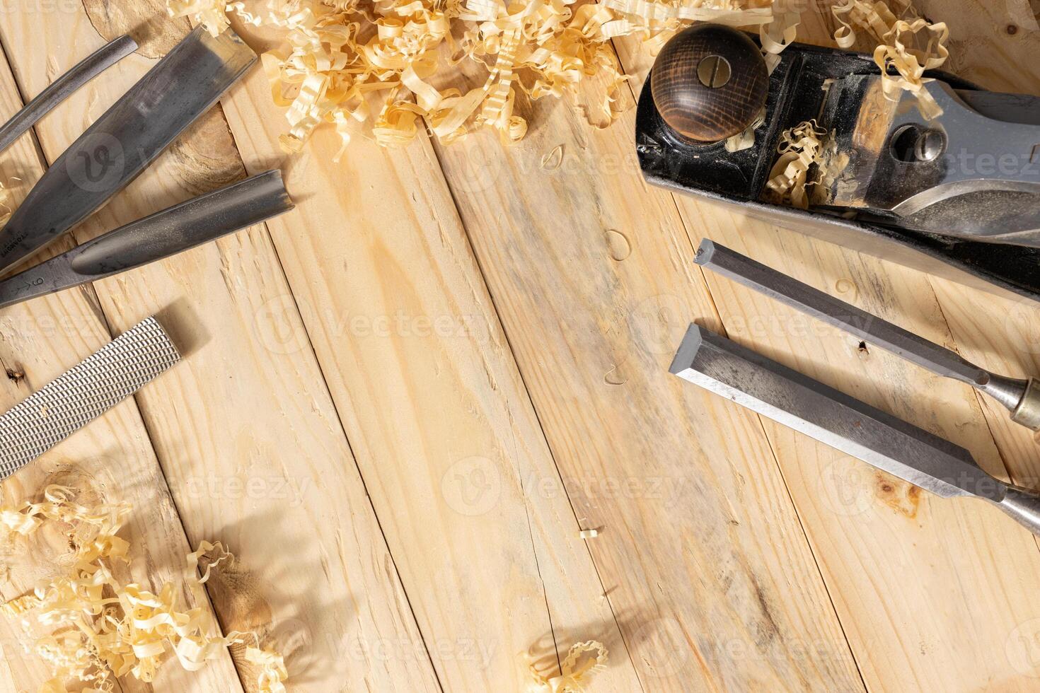 Top view of a traditional carpenter tools and wood shavings lying on wooden planks. Copy space photo