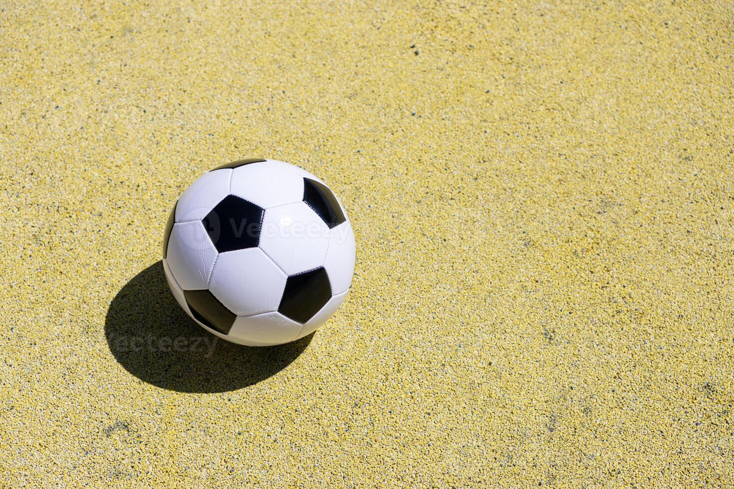 Classic leather soccer ball isolated on yellow color field. Copy space photo