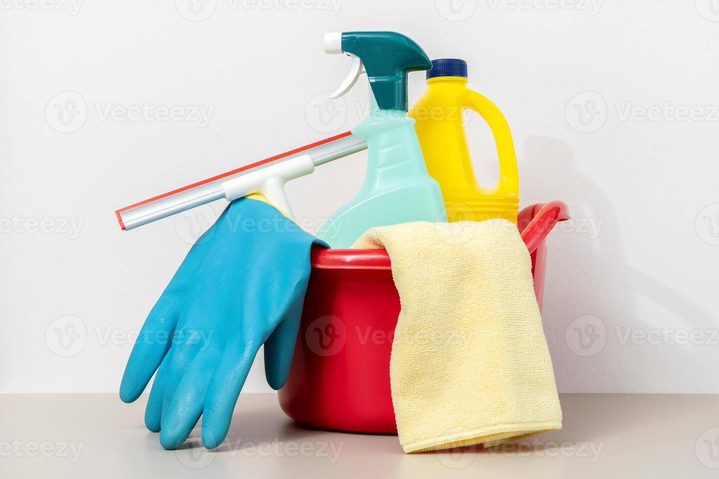 Cleaning supplies in bucket including gloves, microfiber cloth, spray bottle and bleach photo