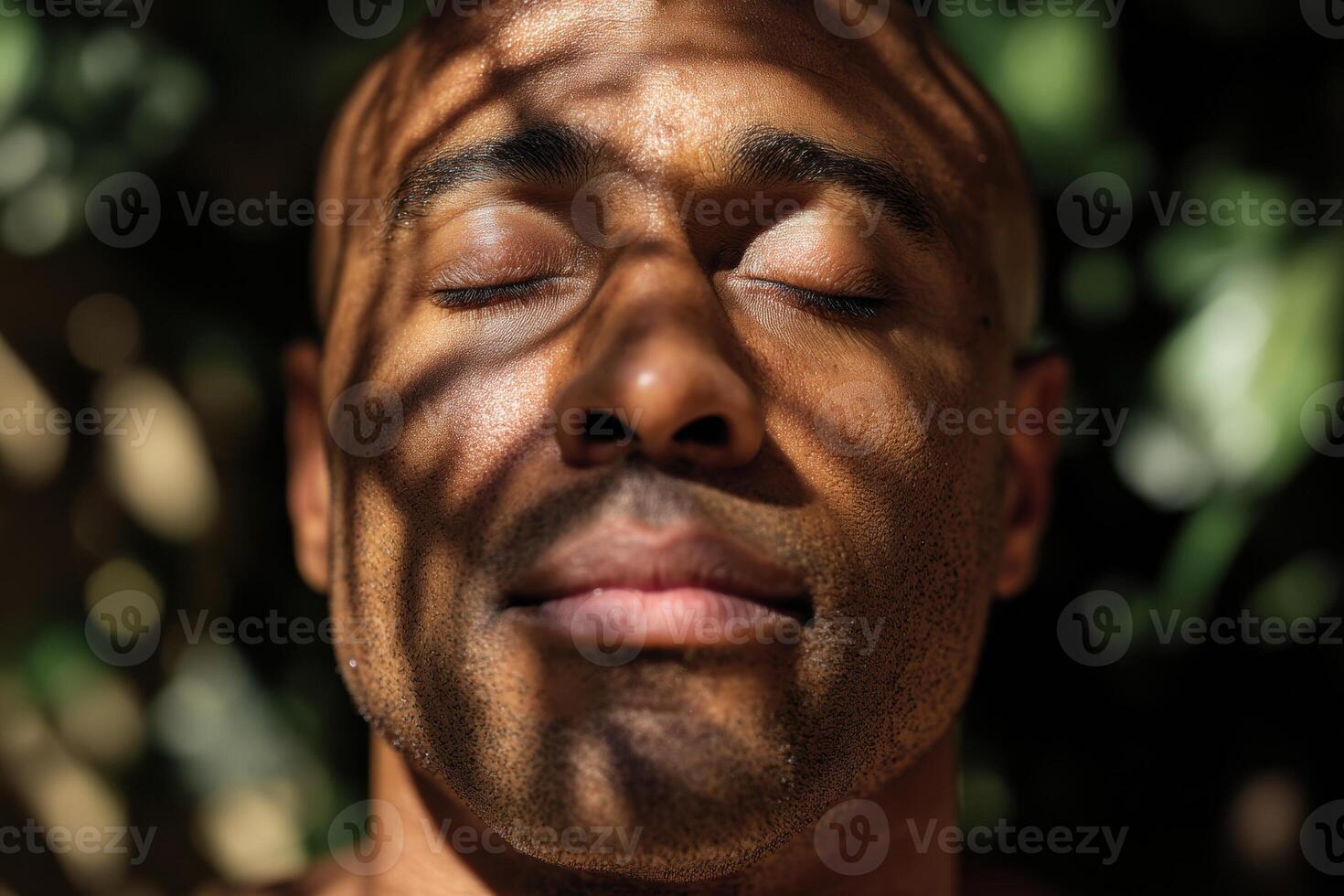 Serene expression of a person with closed eyes, sunlight filtering through leaves casting striped shadows on their face. The play of light and shadow creates a calming atmosphere photo