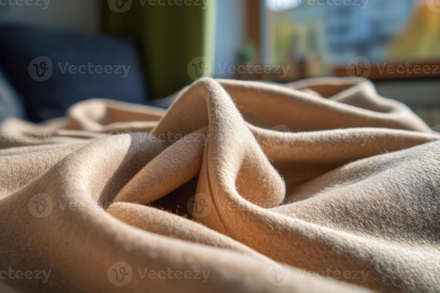 Soft beige fabric with gentle folds, bathed in warm sunlight. The window provides a blurred backdrop. The texture and warmth of the cloth evoke a cozy and inviting atmosphere photo