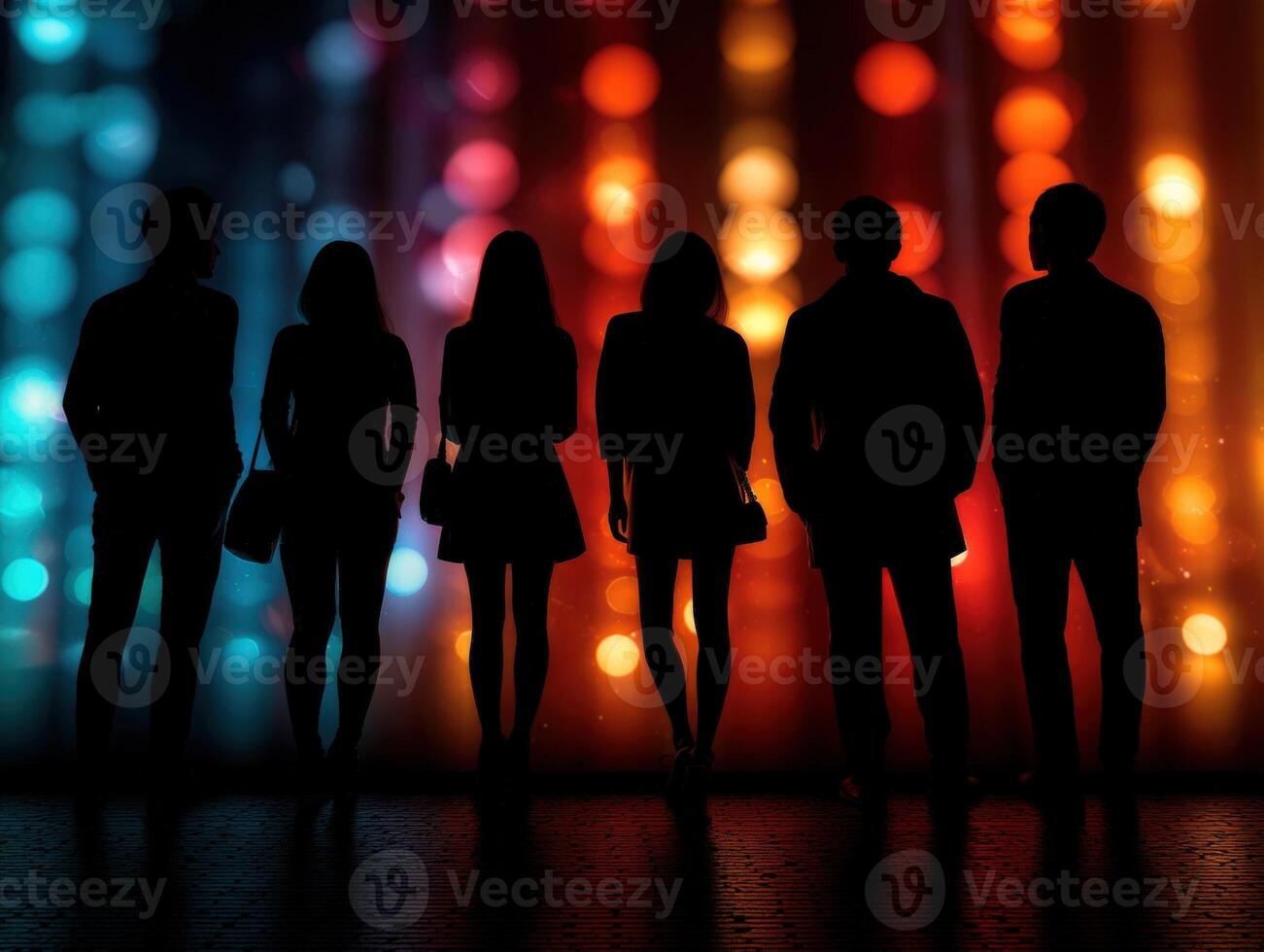 Silhouetted figures of six people stand against a vibrant backdrop of vertically aligned, out-of-focus, colored lights in hues of blue, red, and orange, creating a festive atmosphere photo