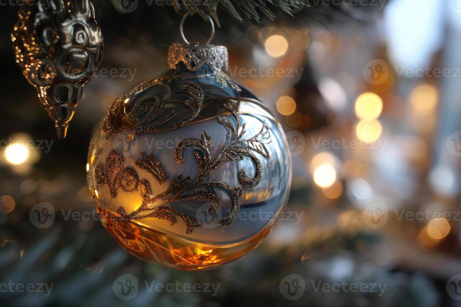 Elegant ornament with intricate gold patterns hangs amid blurred festive lights, casting a warm glow. Green branches create a natural frame, enhancing the holiday atmosphere photo