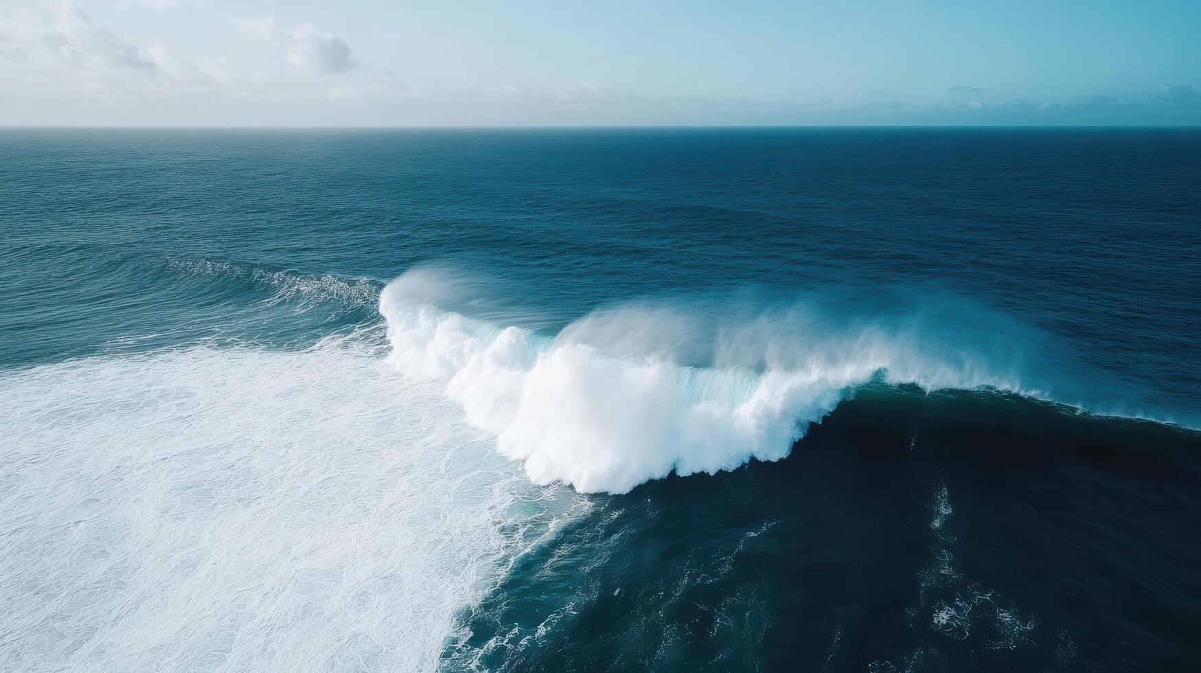 An aerial view of a large wave breaking on the ocean photo