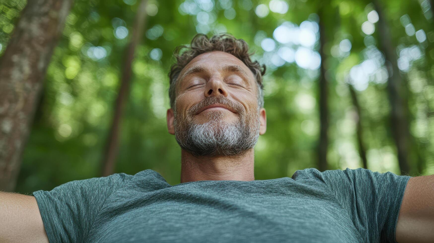 A man with his eyes closed in the woods photo
