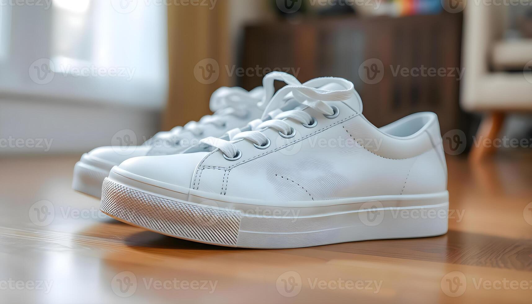 a pair of white sneakers on a wooden floor photo