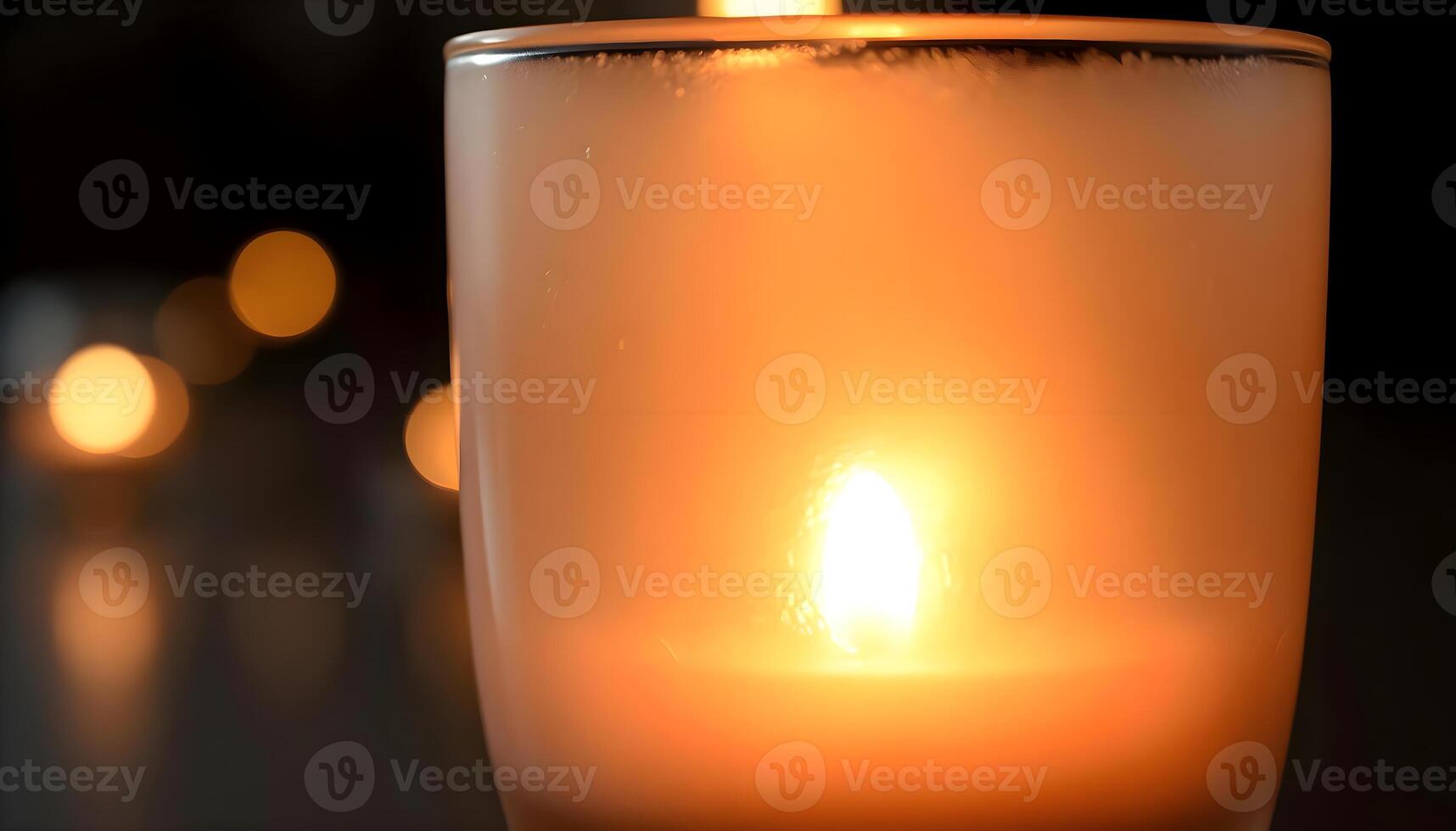 a close up of a lit candle on a table photo