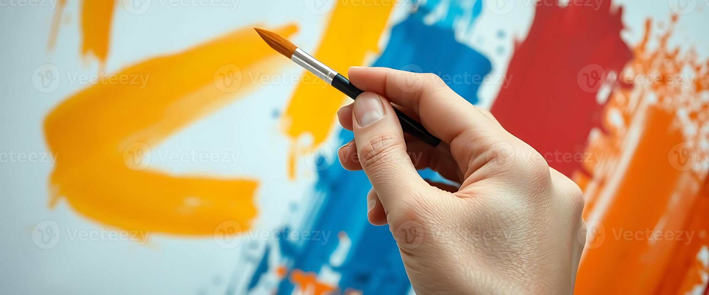 person is holding a paintbrush in their hand photo
