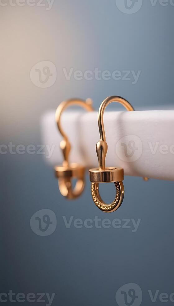 pair of gold earrings hanging from a hook photo