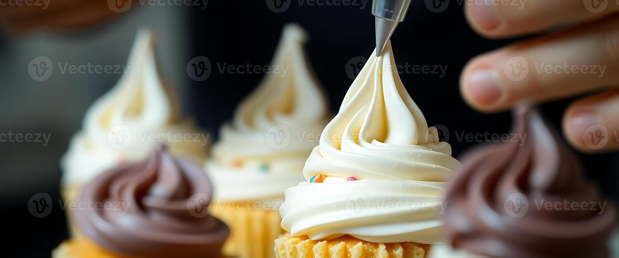 person is decorating cupcakes with white frosting photo