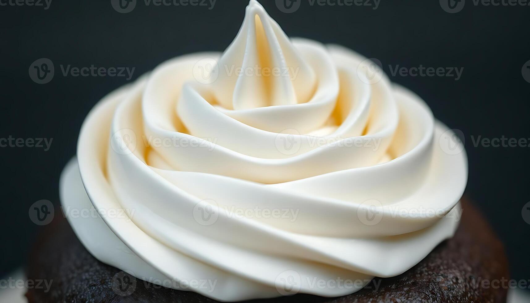 close up of a chocolate cupcake with white frosting photo