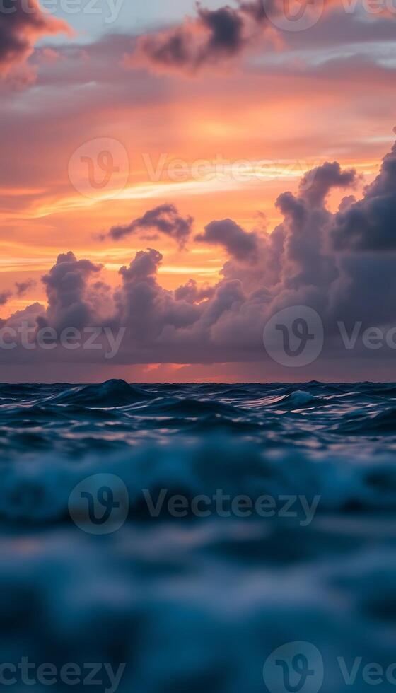 sun is setting over the ocean with clouds photo