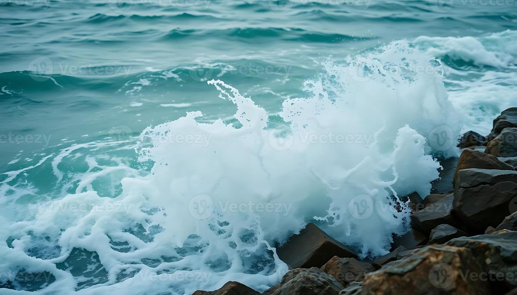 wave crashes against the rocks on the beach photo