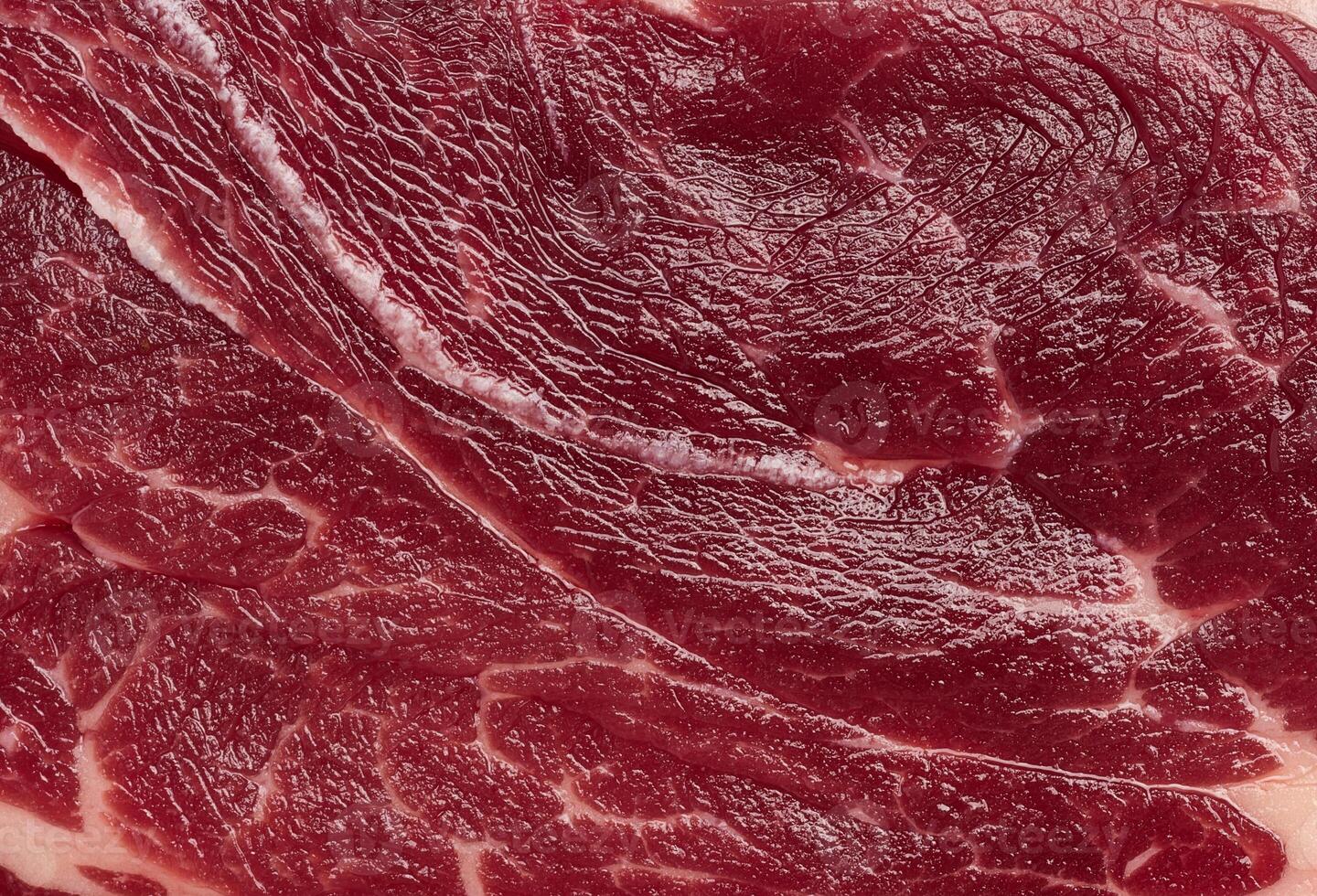 Detailed close up of fresh raw red meat texture with white fat marbling. High quality beef or steak for culinary use photo