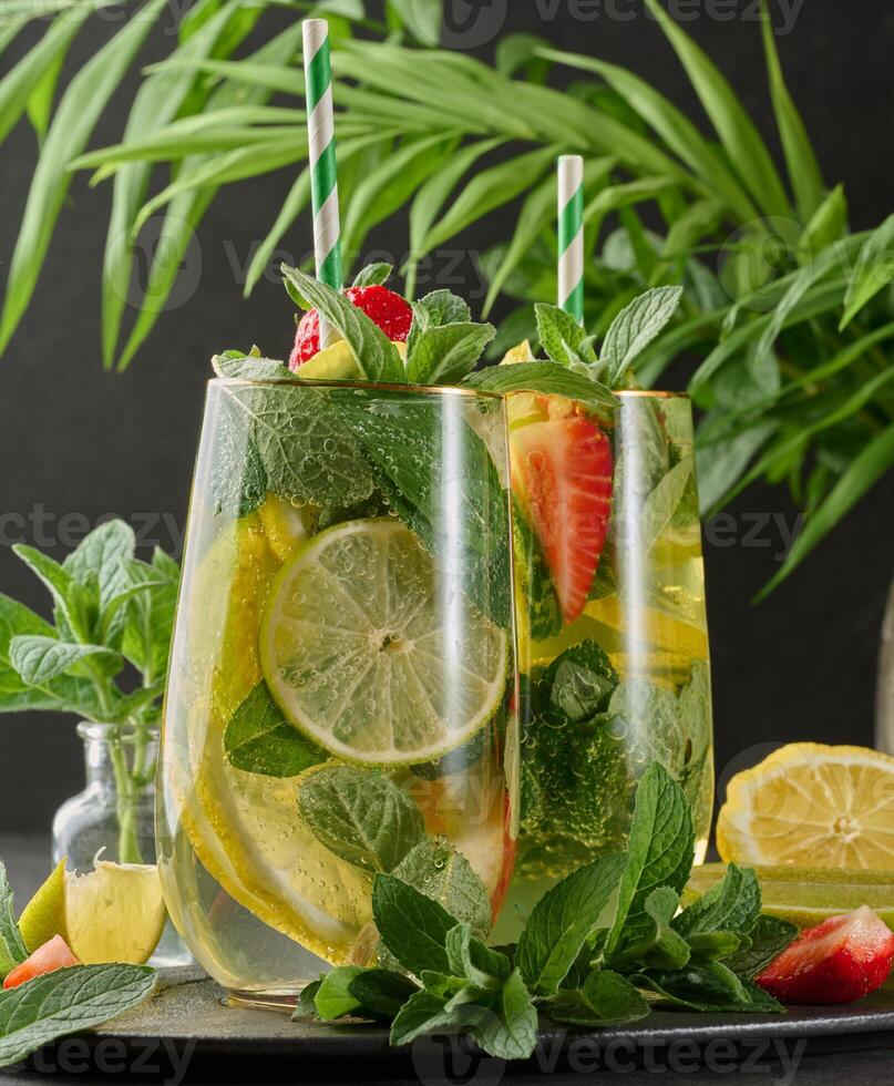 A refreshing drink in a glass with lemon slices, strawberries, fresh mint leaves photo