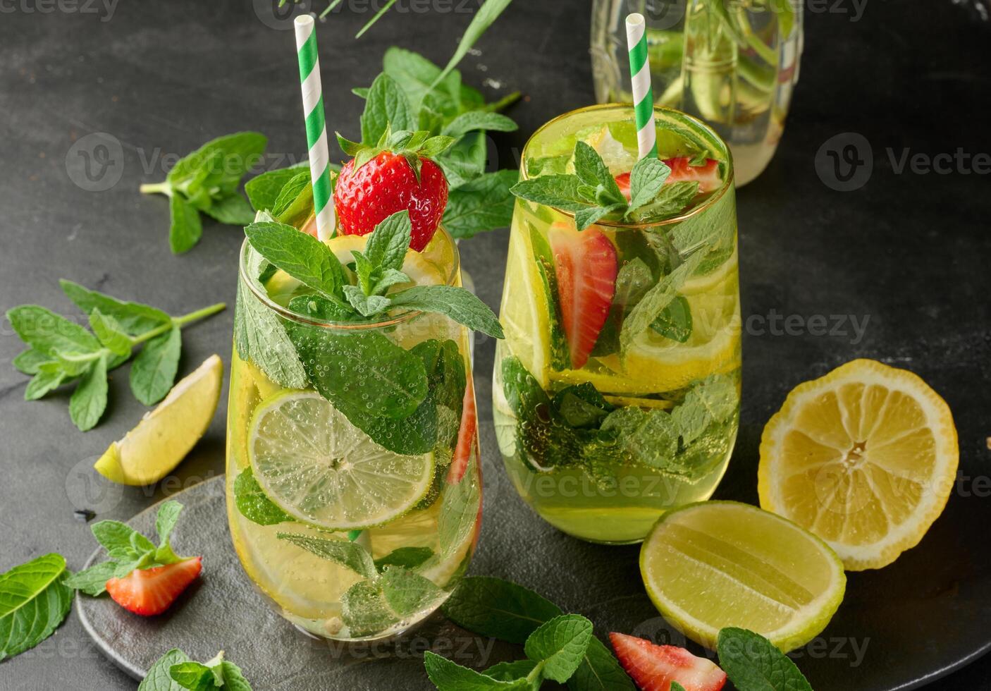 A refreshing drink in a glass with lemon slices, strawberries, fresh mint leaves, and sparkling water. Top view photo