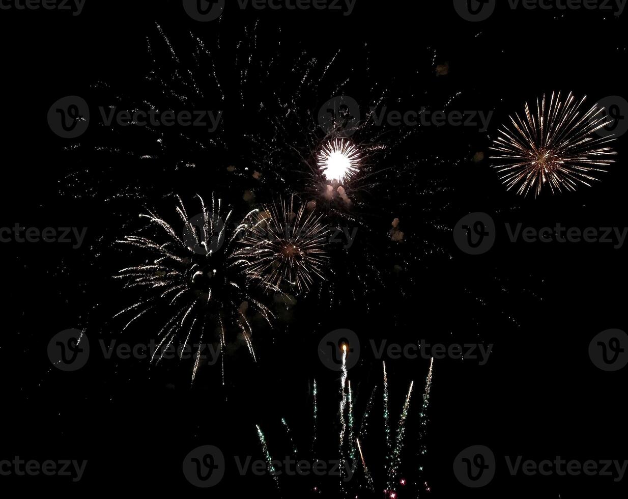 Spectacular fireworks display exploding against a dark night sky. Perfect for celebratory themes, holiday greetings, or event promotion. photo