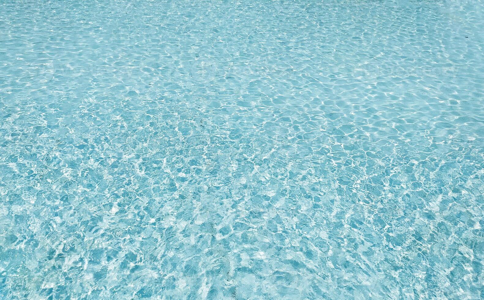 Serene turquoise water shimmers, a tranquil surface texture perfect for backgrounds, websites, or travel brochures. Its calming aesthetic evokes peace, relaxation, and summer vibes. photo